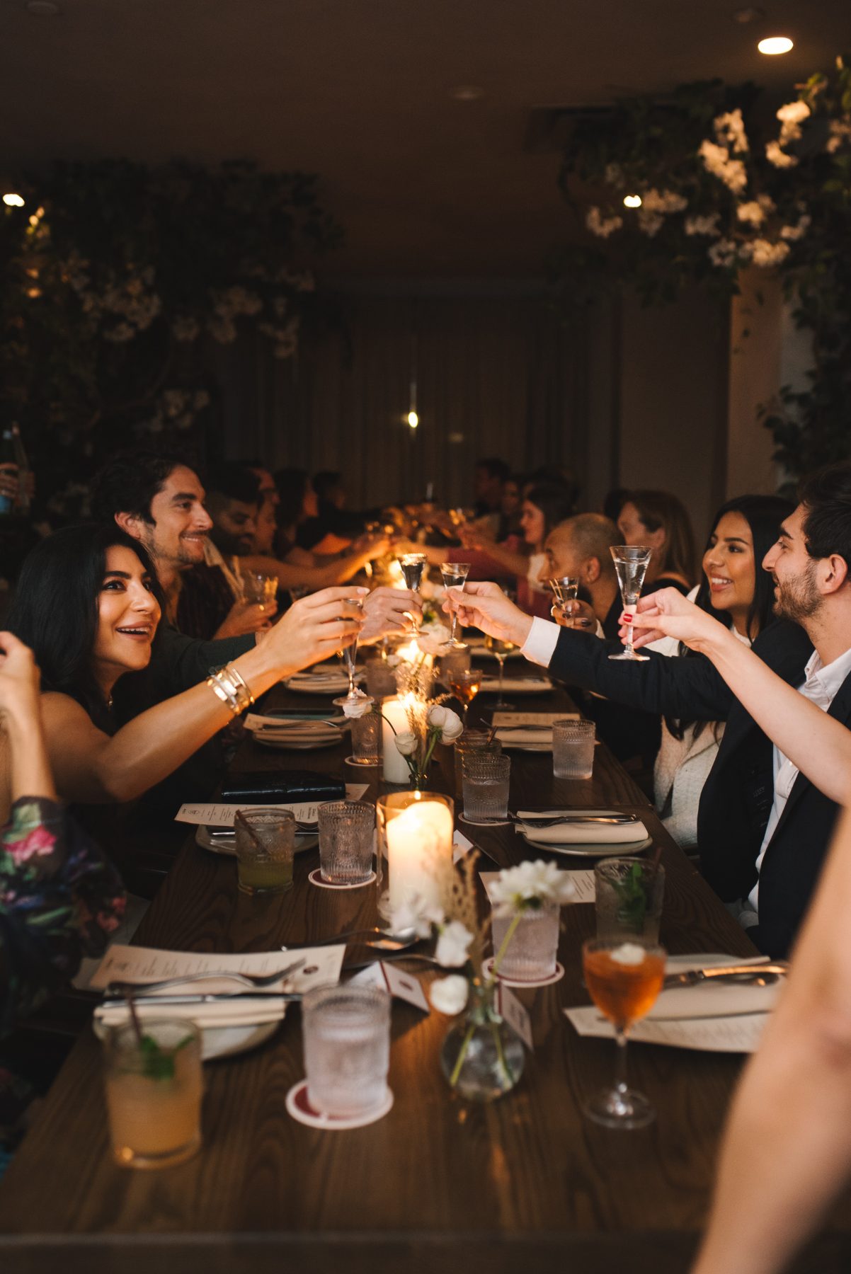 Guests toasting along a long candlelit table