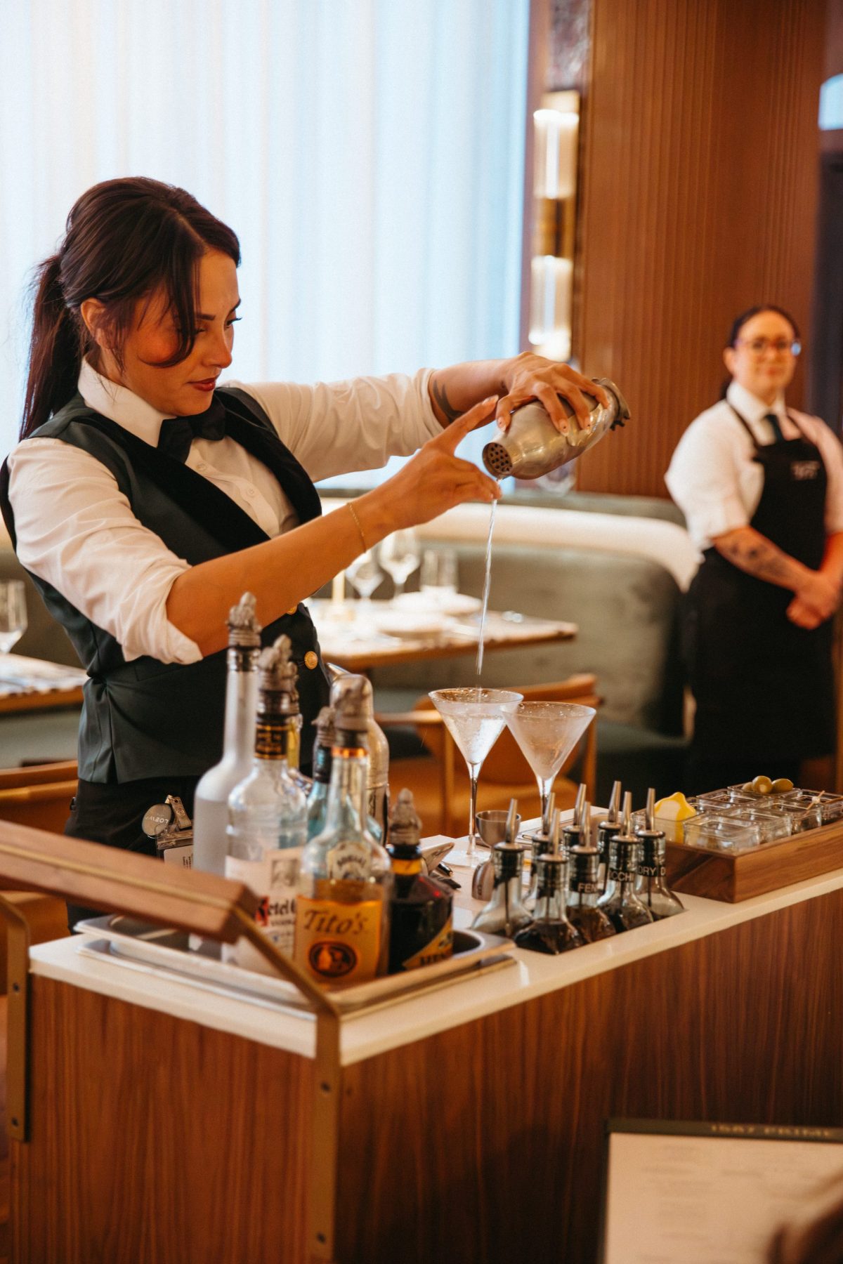 A Noble 33 bartender building a cocktail